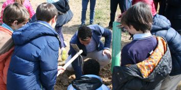 Alumnos del colegio Zola plantando un árbol