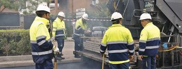 Cinco operarios esparcen el asfalto en la avenida de Logroño