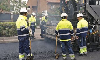 Cinco operarios esparcen el asfalto en la avenida de Logroño