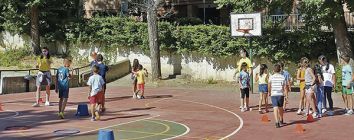 Niños jugando en el patio de una pista deportiva a reformar