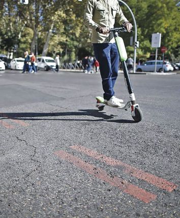 El conductor de un patinete elctrico transita por el centro de la capital