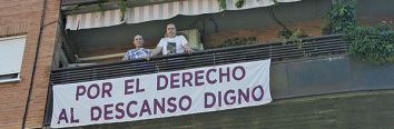 José María y Manuel, con una de las pancartas que han colocado en su balcón