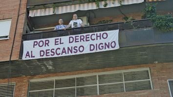 José María y Manuel, con una de las pancartas que han colocado en su balcón